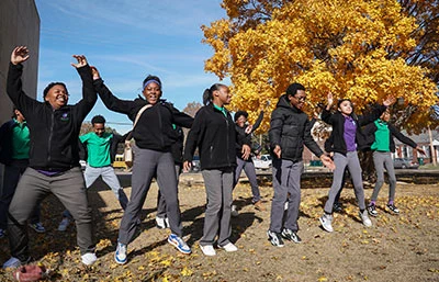 A group of scholars jumping joyfully outdoors